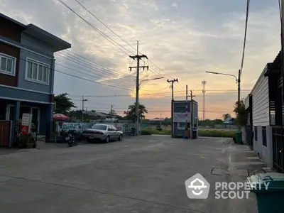 Charming residential street view at sunset with modern homes and open sky.