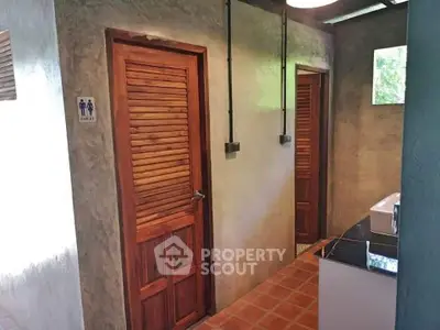Rustic bathroom hallway with wooden doors and natural lighting