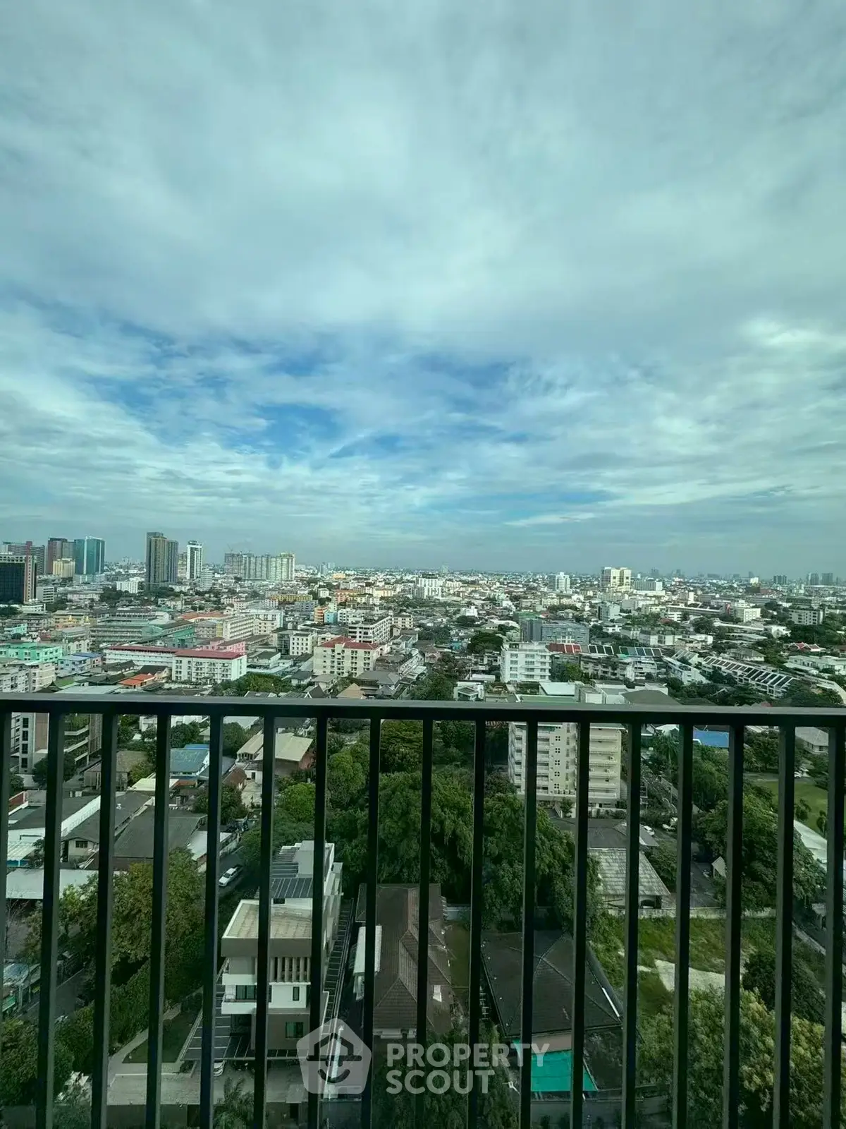 Stunning cityscape view from a high-rise balcony showcasing urban skyline and greenery.