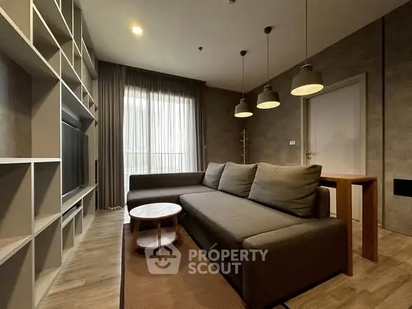 Modern living room with stylish sofa and pendant lights, featuring a cozy ambiance.