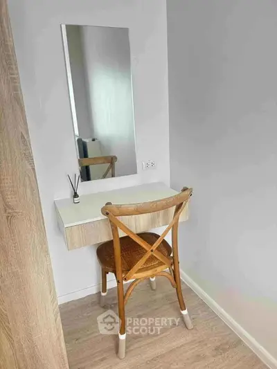 Cozy study nook with wooden chair and minimalist desk, perfect for focused work or reading.