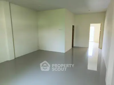 Spacious empty room with glossy flooring and natural light, ideal for customization.