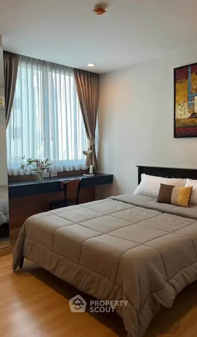 Modern bedroom with cozy decor and large window, featuring a comfortable bed and stylish furnishings.