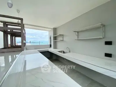 Modern open kitchen with sleek countertops and ocean view