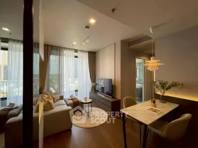 Modern living room with cozy seating and dining area, featuring elegant lighting and large windows.