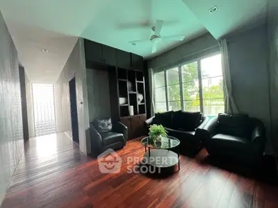 Spacious living room with elegant wooden flooring and large windows offering natural light.