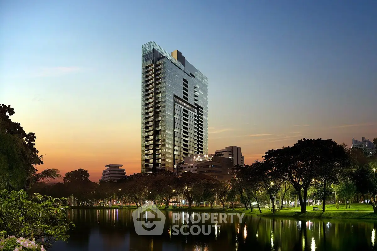 Stunning high-rise building with serene lakeside view at sunset, perfect for luxury urban living.