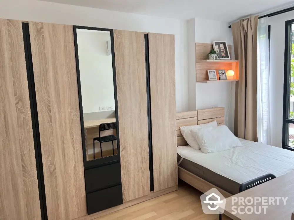 Modern bedroom with sleek wooden wardrobe and cozy bed, perfect for urban living.