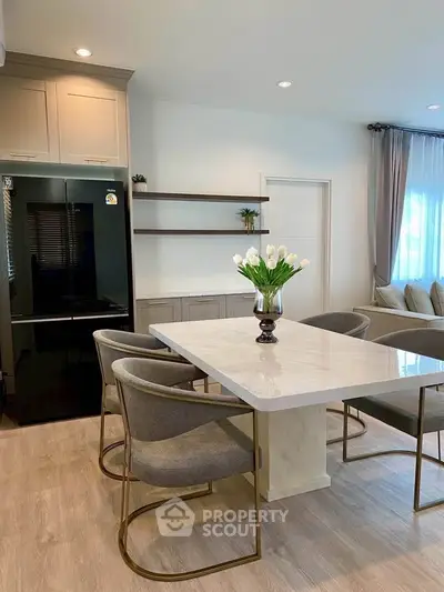 Modern dining area with elegant marble table and stylish chairs in a bright, open-concept living space.