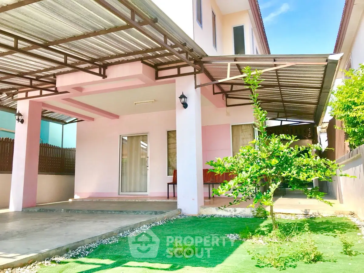 Charming two-story house with covered patio and lush green garden in a serene neighborhood.