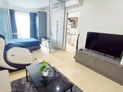 Modern living room with massage chair and TV, open layout to bedroom and kitchen