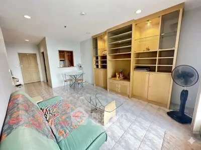 Spacious living room with built-in shelves and cozy seating area in modern apartment.