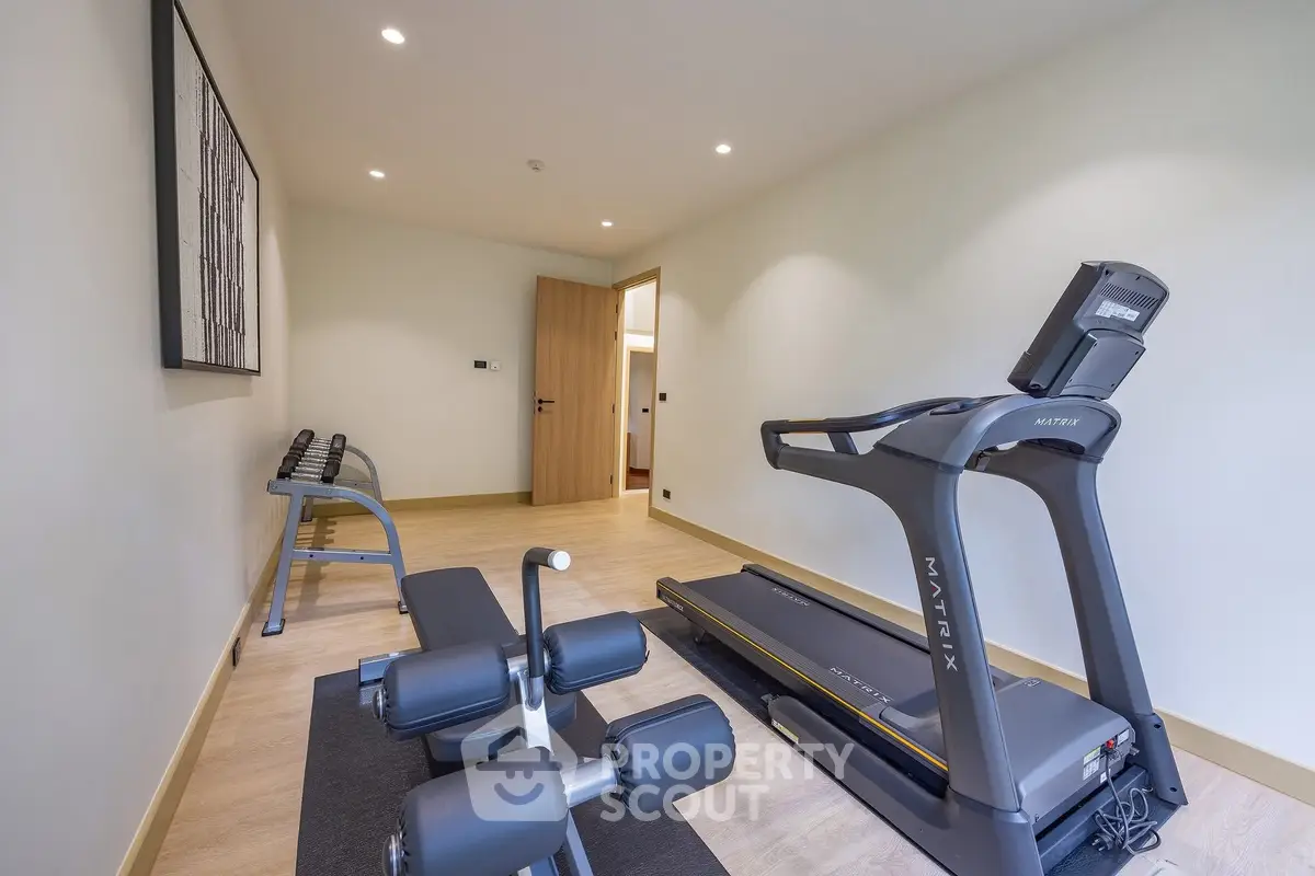 Modern home gym with treadmill and weights in sleek interior design