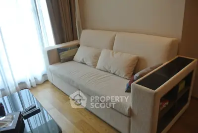 Cozy living room with plush beige sofa and wooden flooring, perfect for relaxation.