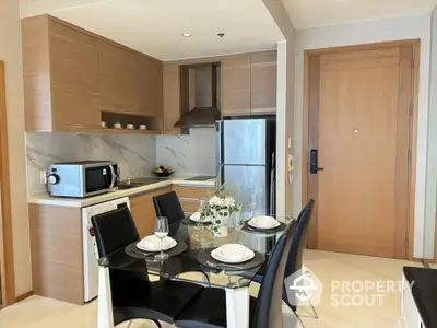 Modern kitchen with sleek appliances and stylish dining area in a contemporary apartment.