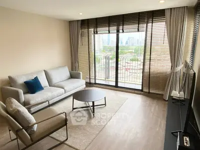 Modern living room with city view, stylish furniture, and large windows for natural light.
