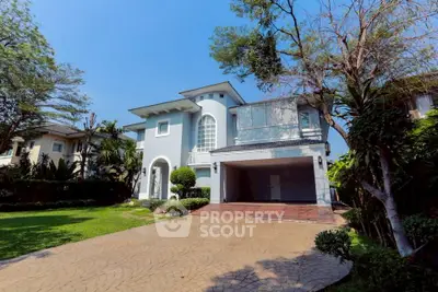 Elegant two-story house with spacious driveway and lush garden, perfect for family living.