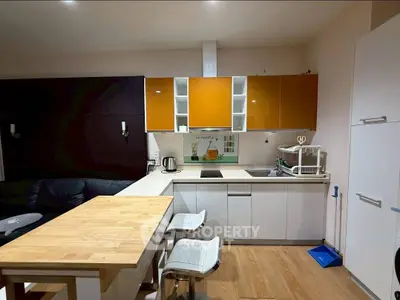 Modern kitchen with sleek cabinets and breakfast bar in cozy apartment.