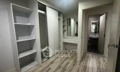 Spacious walk-in closet with modern shelving and mirror in a stylish home.
