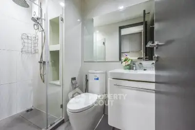 Modern bathroom with sleek fixtures and glass shower enclosure in a contemporary apartment.
