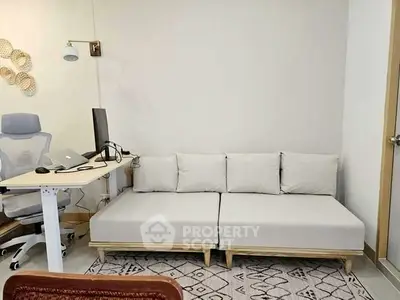 Modern study room with ergonomic chair, adjustable desk, and cozy sofa.