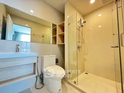 Modern bathroom with glass shower and sleek fixtures in a contemporary home.
