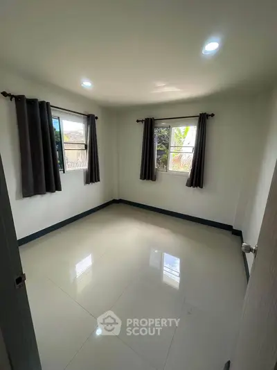 Spacious unfurnished room with large windows and tiled flooring, perfect for customization.