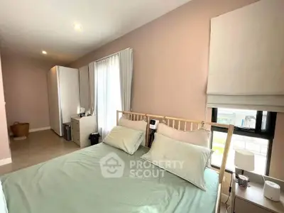 Cozy bedroom with natural light and modern decor, featuring a comfortable bed and stylish furnishings.