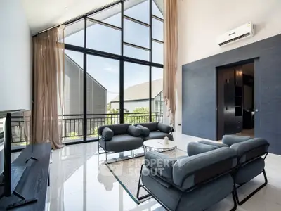 Spacious modern living room with high ceilings and large windows offering abundant natural light.