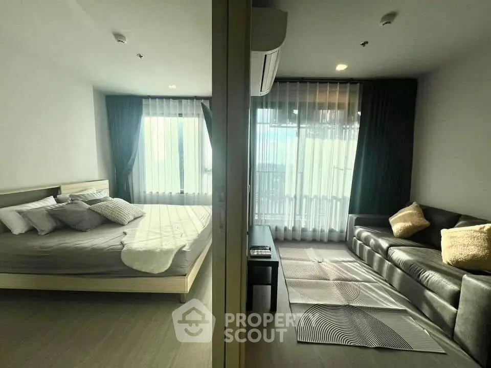 Modern condo with cozy bedroom and stylish living room, featuring large windows and elegant decor.