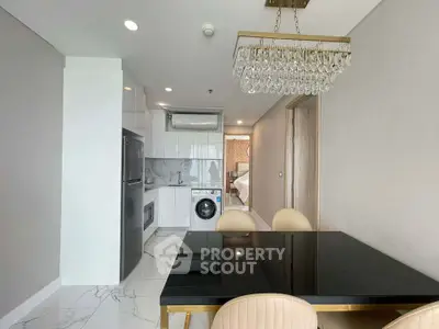 Modern kitchen with sleek appliances and elegant dining area in a stylish apartment.