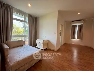 Spacious and bright living area with elegant wooden flooring and large windows.