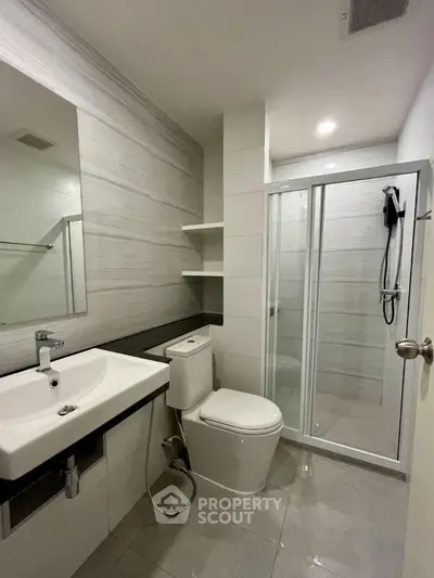 Modern bathroom with sleek fixtures and glass shower enclosure