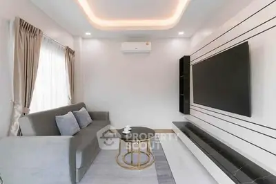 Modern living room with sleek design, featuring a large TV, stylish sofa, and elegant lighting.