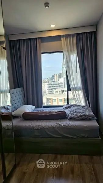 Cozy bedroom with city view and elegant curtains in modern apartment
