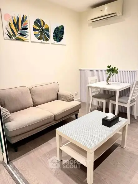 Cozy living room with modern decor, featuring a comfortable sofa, dining table, and stylish wall art.