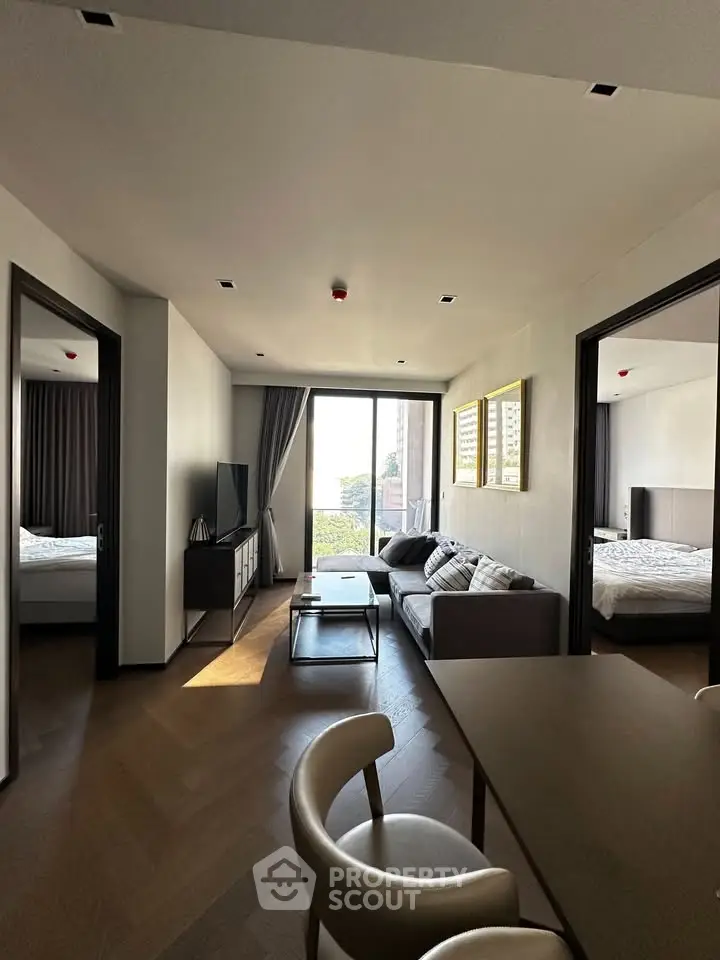 Modern living room with stylish furniture and natural light, connecting to two bedrooms with a scenic view.