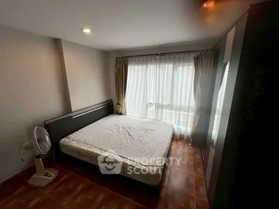 Spacious bedroom with large window and natural light, featuring a comfortable bed and modern decor.