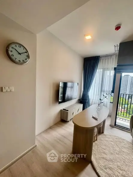 Modern living room with wall-mounted TV and balcony view in high-rise apartment
