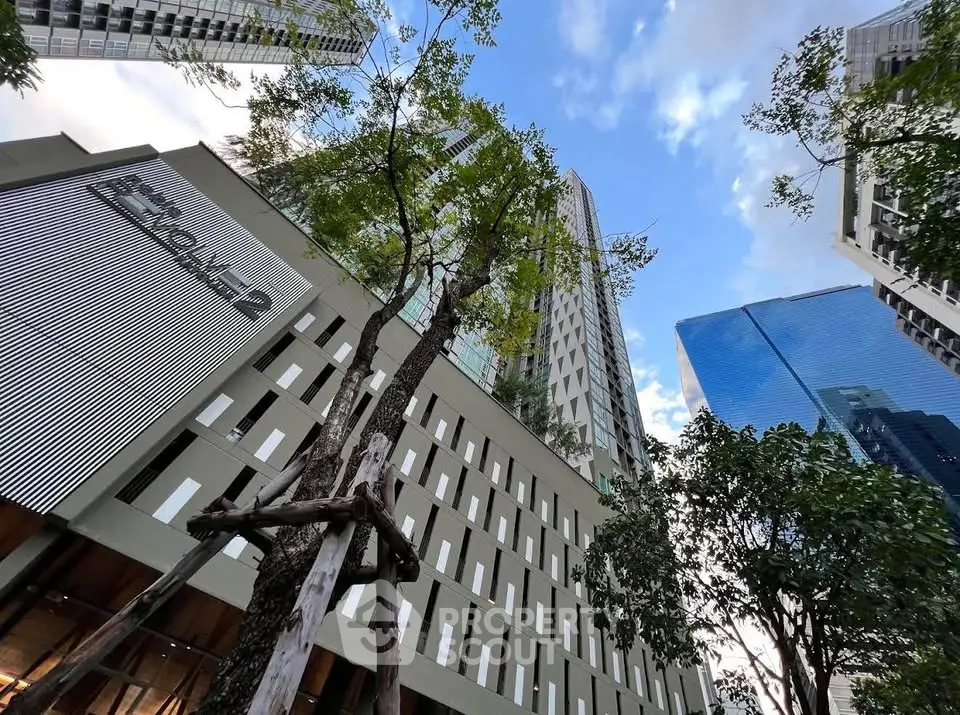 Stunning modern high-rise building with lush greenery and blue sky backdrop.