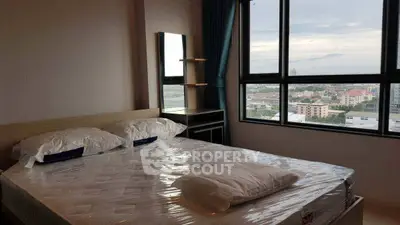 Modern bedroom with large window offering city view and natural light.