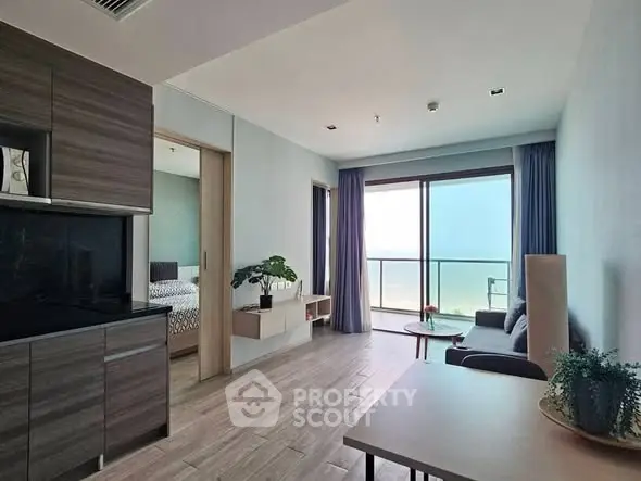 Modern apartment interior with open layout, featuring a cozy living room and stunning balcony view.