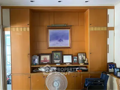 Spacious living room with elegant wooden cabinetry and artistic decor, perfect for stylish home living.