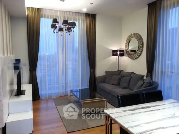 Modern living room with stylish decor and large windows offering city views.