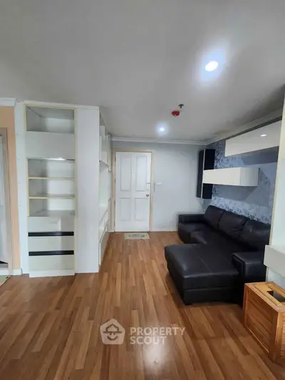 Modern living room with sleek black sofa and built-in shelving