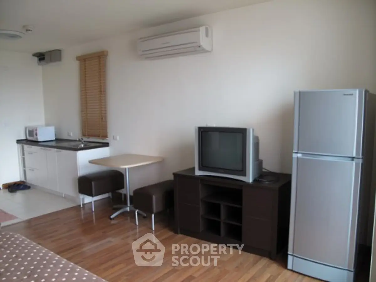 Modern studio apartment with compact kitchen and cozy living area.