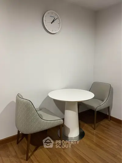 Cozy corner with modern chairs and round table, perfect for intimate conversations.