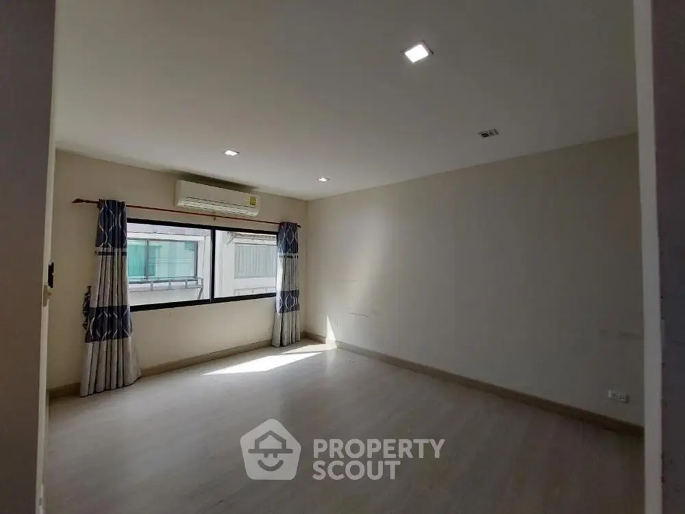 Spacious unfurnished room with large window and air conditioning