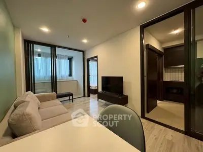 Modern living room with open layout and stylish kitchen in contemporary apartment.