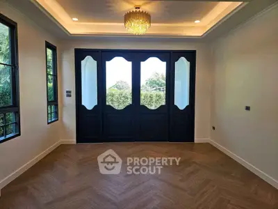 Elegant living room with herringbone wood flooring and large windows for natural light.